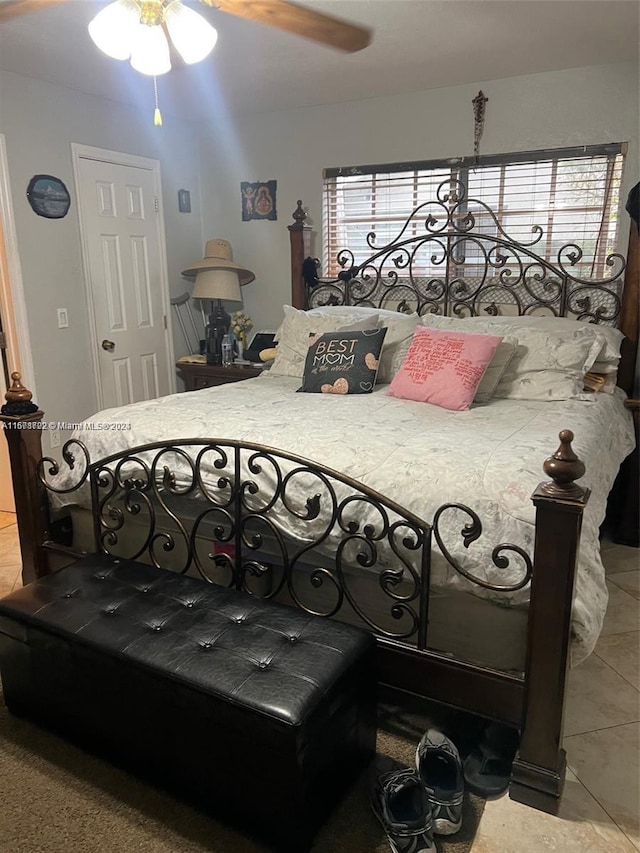 tiled bedroom featuring multiple windows and ceiling fan