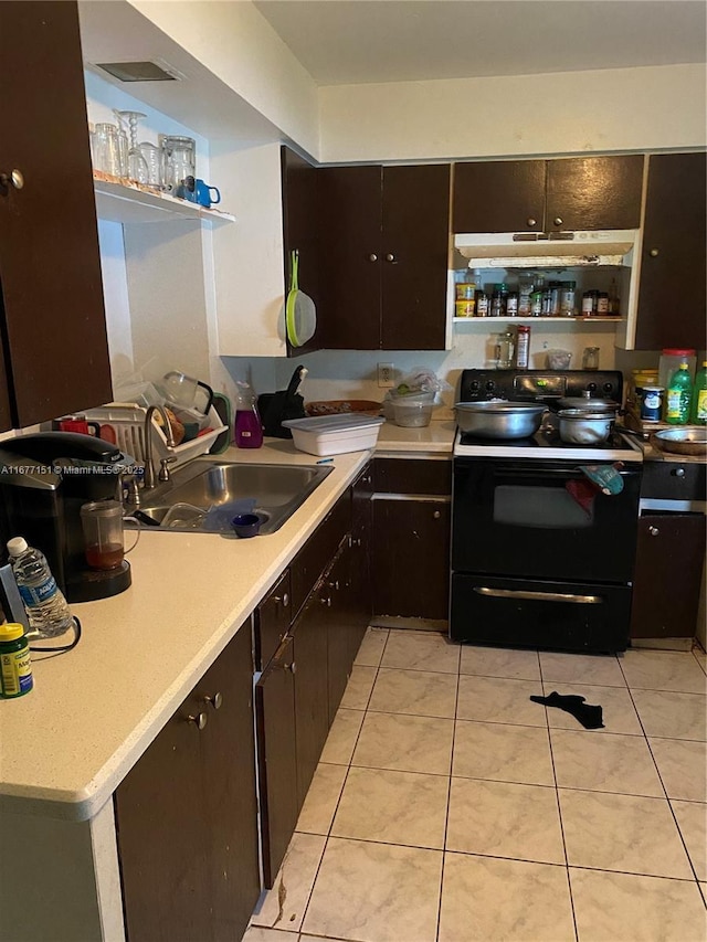 kitchen with black range with electric stovetop, sink, light tile patterned floors, and dark brown cabinetry