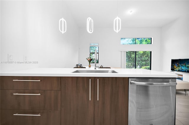 kitchen with stainless steel dishwasher, decorative light fixtures, dark brown cabinetry, and sink