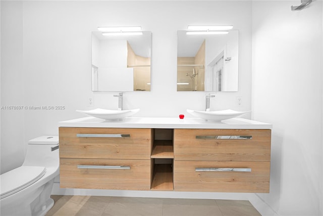 bathroom featuring tile patterned floors, vanity, toilet, and a shower with shower door