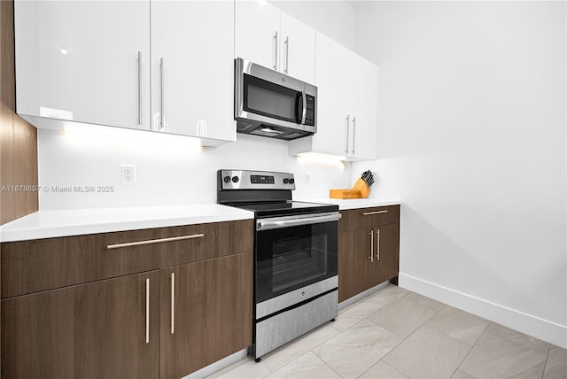 kitchen featuring dark brown cabinetry, white cabinetry, and appliances with stainless steel finishes