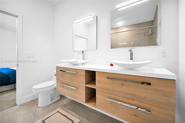 bathroom with toilet, vanity, tile patterned floors, and a shower with shower door