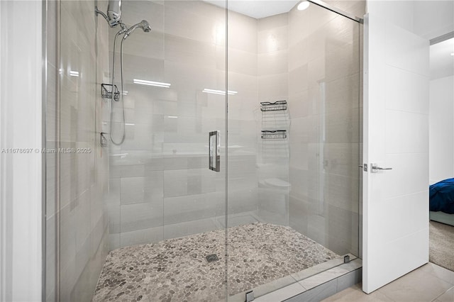 bathroom featuring tile patterned floors and a shower with shower door