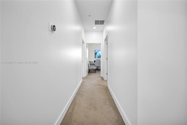 corridor featuring light colored carpet