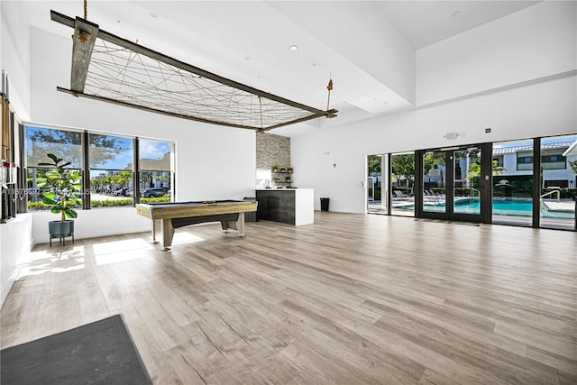 rec room featuring hardwood / wood-style floors, a high ceiling, and pool table