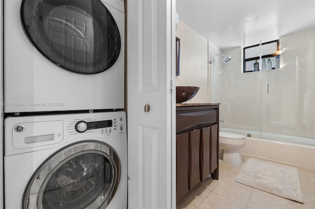 laundry room with light tile patterned flooring and stacked washer and dryer