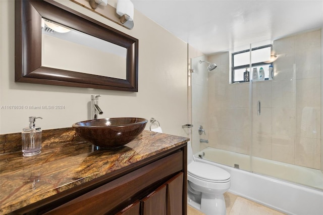 full bathroom with toilet, bath / shower combo with glass door, and vanity