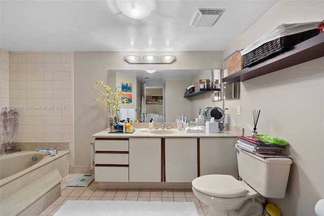 bathroom with vanity, toilet, a tub to relax in, and tile patterned floors