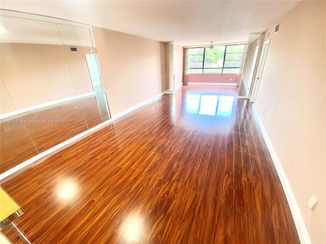 unfurnished room featuring dark hardwood / wood-style flooring and expansive windows