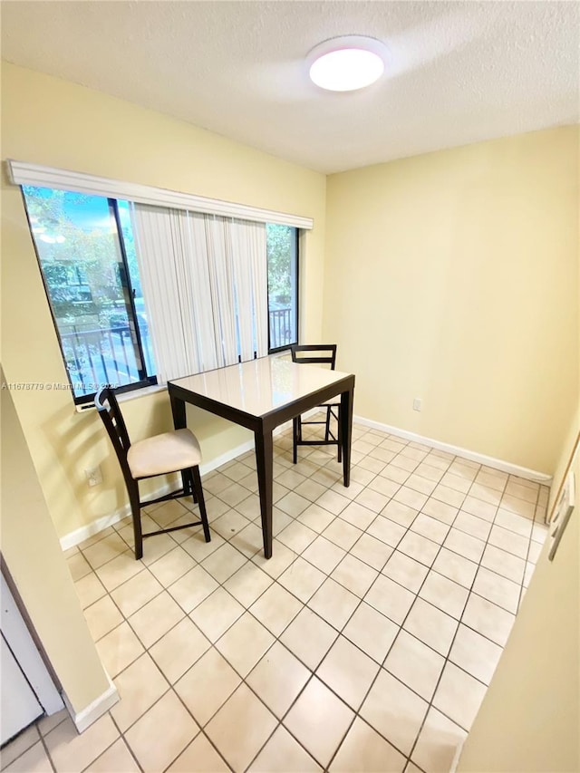 tiled dining room with a textured ceiling