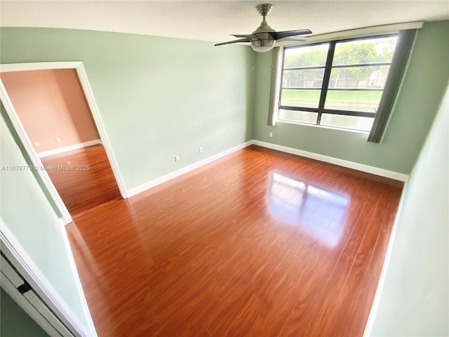 spare room with hardwood / wood-style flooring and ceiling fan