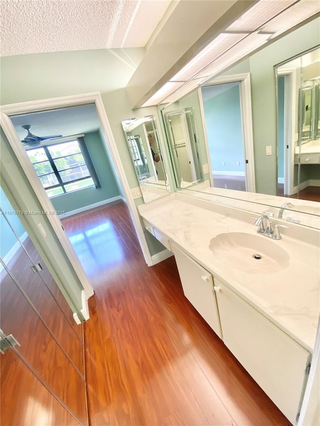 bathroom with wood-type flooring, a textured ceiling, and vanity