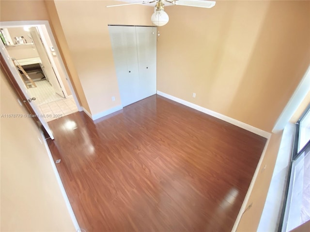 interior space with dark wood-type flooring, a closet, and ceiling fan