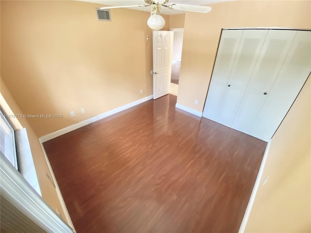 unfurnished bedroom featuring a closet, ceiling fan, and dark hardwood / wood-style flooring