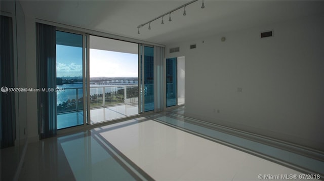 empty room featuring a water view and track lighting