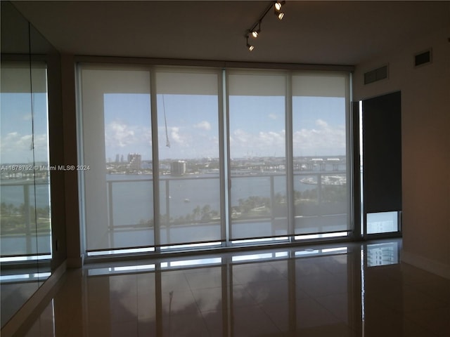 empty room featuring a water view and rail lighting