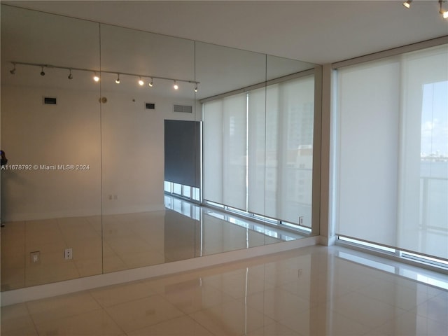 unfurnished room featuring rail lighting and tile patterned floors