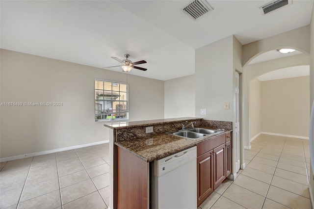 kitchen featuring ceiling fan, white dishwasher, dark stone counters, light tile patterned flooring, and sink