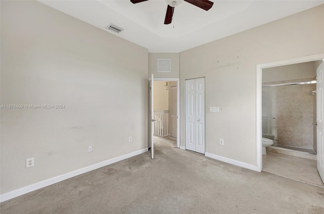 unfurnished bedroom featuring connected bathroom, light carpet, a closet, and ceiling fan