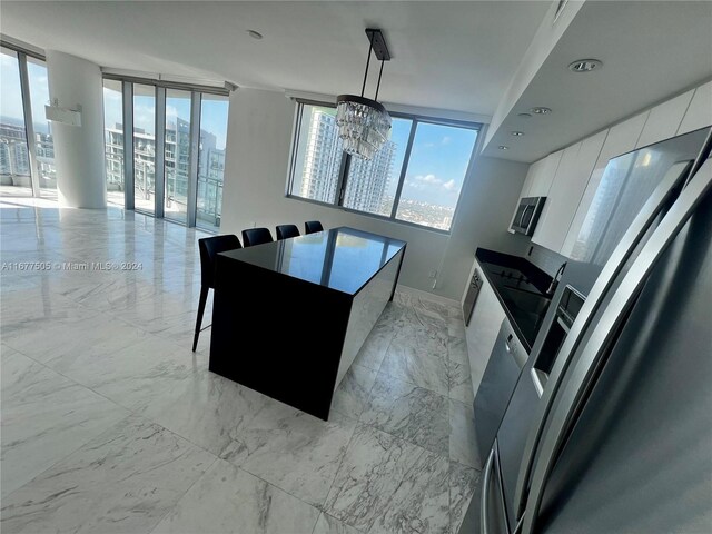 92 SW 3rd Unit 3605, Miami, FL 33130 - kitchen featuring modern cabinets, a chandelier, light marble finish floors, white cabinets, and pendant lighting