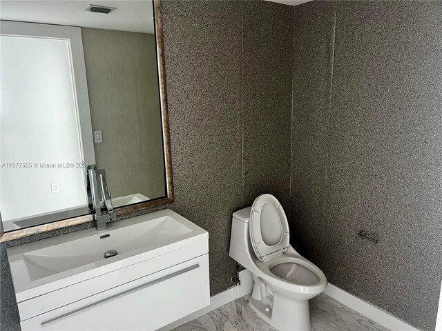 92 SW 3rd Unit 3605, Miami, FL 33130 - half bathroom with marble finish flooring, toilet, vanity, and baseboards