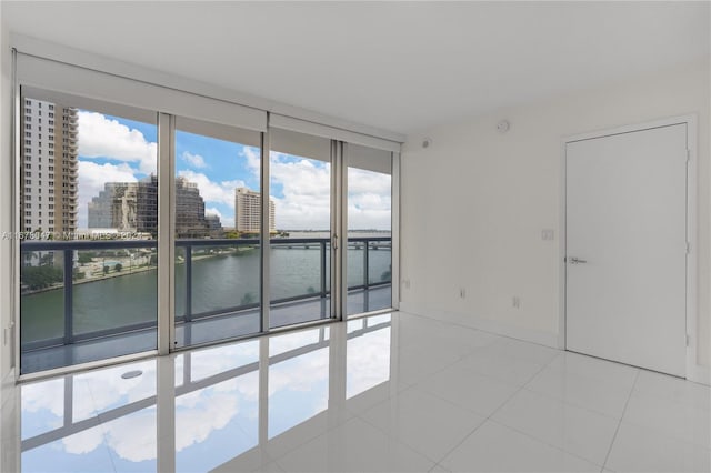 tiled spare room featuring a water view