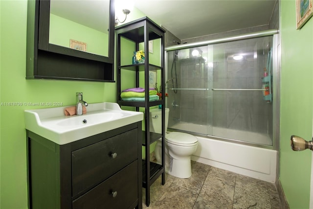 full bathroom featuring vanity, bath / shower combo with glass door, and toilet