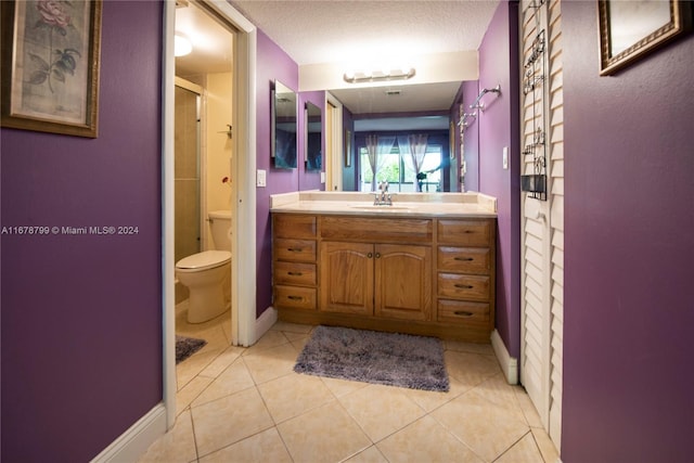 bathroom featuring toilet, walk in shower, vanity, and tile patterned flooring