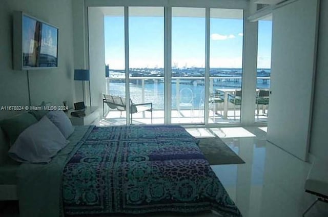 bedroom with multiple windows and a water view