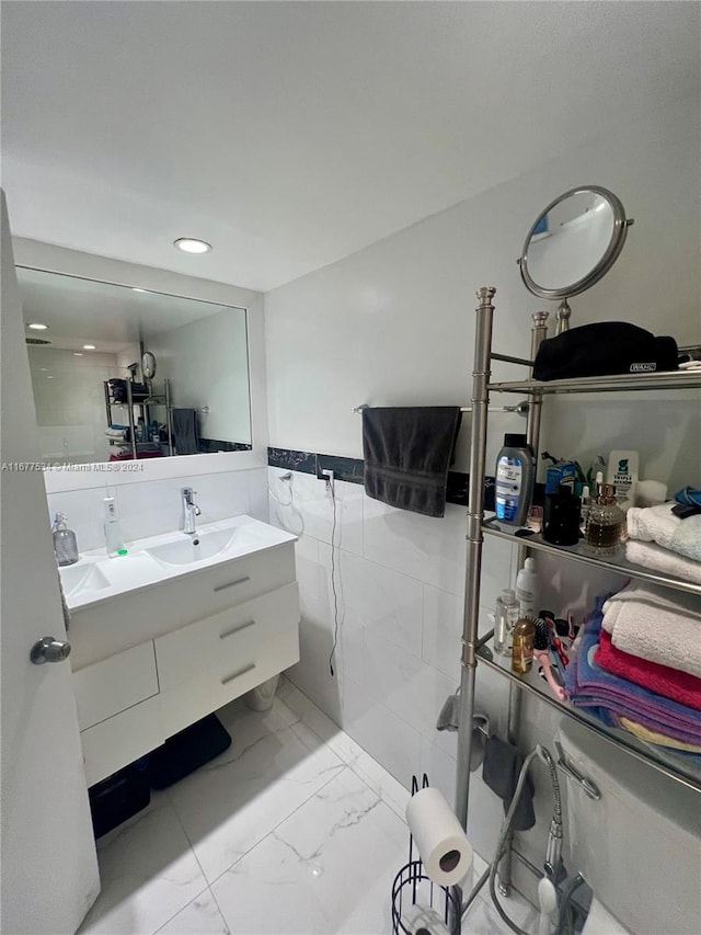 bathroom featuring vanity and tile walls