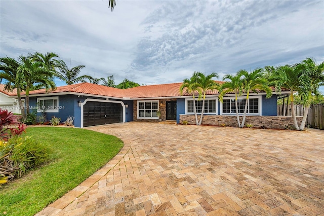 ranch-style house featuring a front yard and a garage