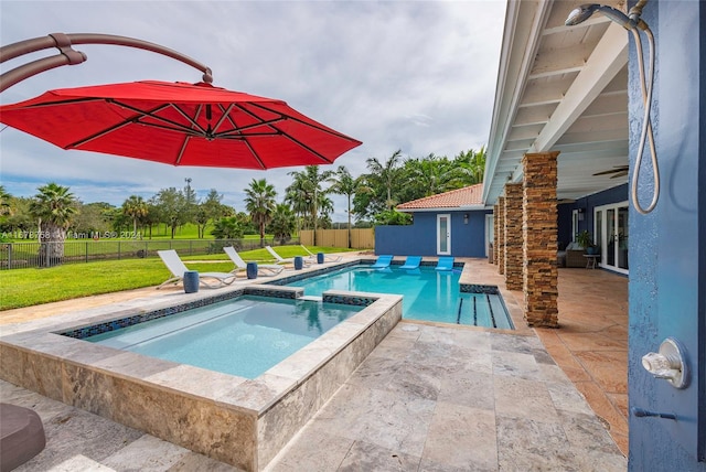 view of pool featuring an in ground hot tub, a patio, and a lawn