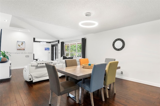 dining area featuring lofted ceiling, a textured ceiling, and dark hardwood / wood-style flooring