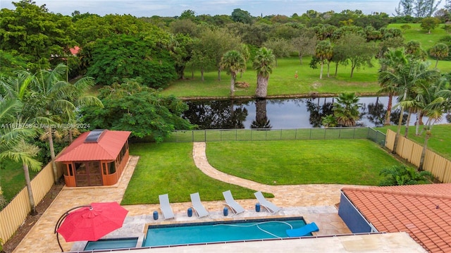 view of pool featuring a water view, a patio, and a yard