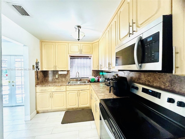 kitchen featuring electric range, sink, french doors, backsplash, and light tile patterned floors