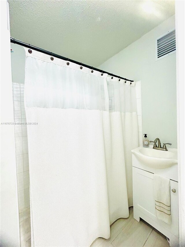 bathroom featuring vanity and a textured ceiling