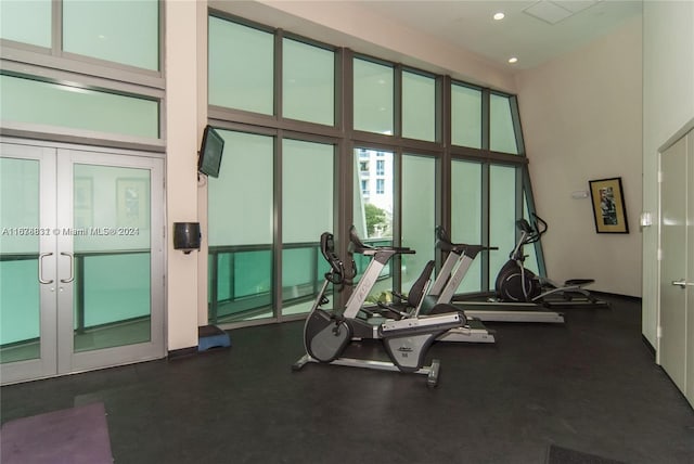 gym with french doors and a high ceiling