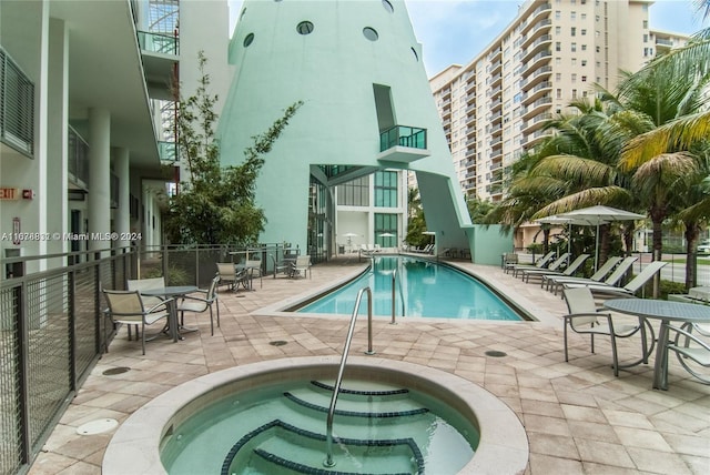 view of pool with a community hot tub and a patio area