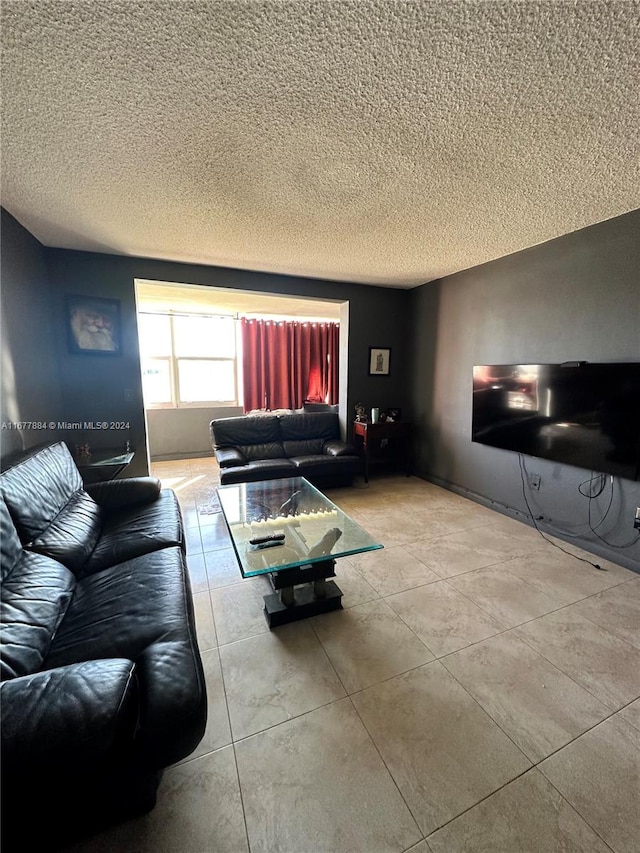 living room with a textured ceiling and light tile patterned floors