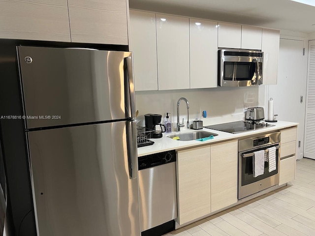 kitchen with sink, appliances with stainless steel finishes, and white cabinetry