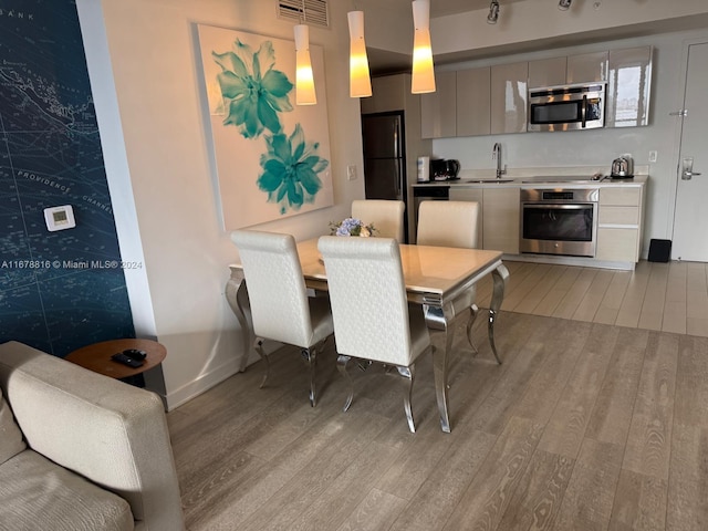 dining space featuring light hardwood / wood-style floors and sink