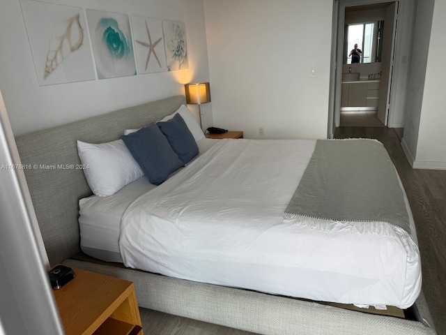 bedroom featuring dark hardwood / wood-style floors and ensuite bathroom