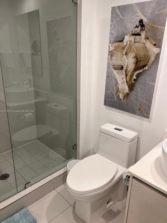 bathroom with vanity, toilet, tile patterned flooring, and an enclosed shower