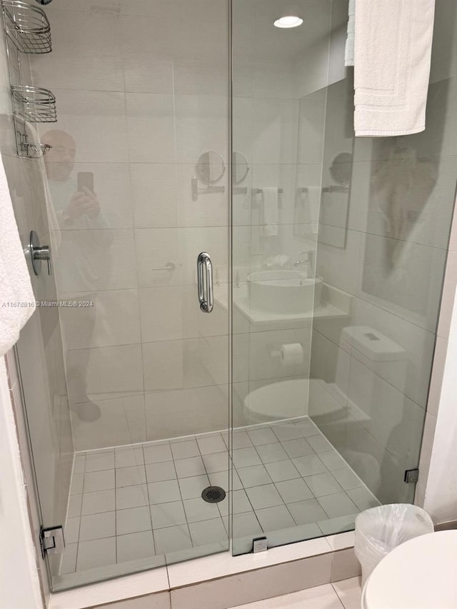 bathroom featuring toilet and a shower with shower door