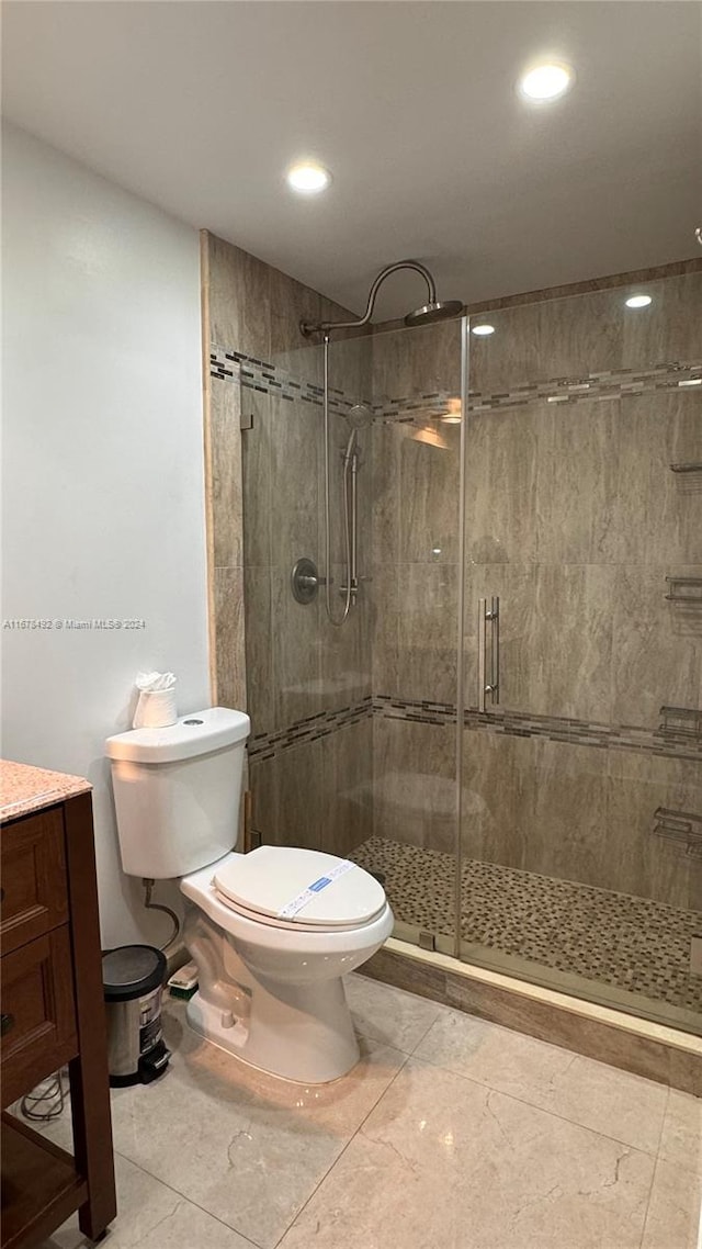 bathroom with vanity, toilet, tile patterned flooring, and an enclosed shower