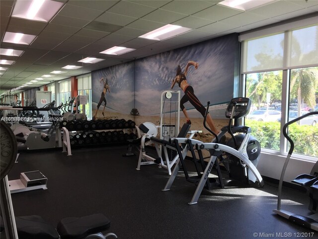 gym with a healthy amount of sunlight and a drop ceiling