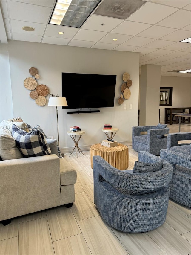 living room featuring light hardwood / wood-style floors and a drop ceiling