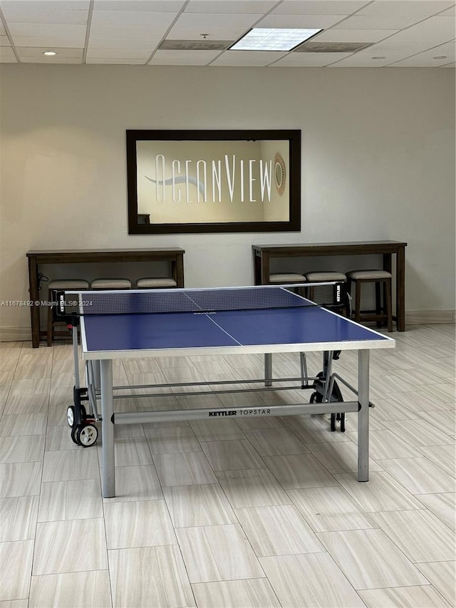 game room with a drop ceiling and tile patterned flooring