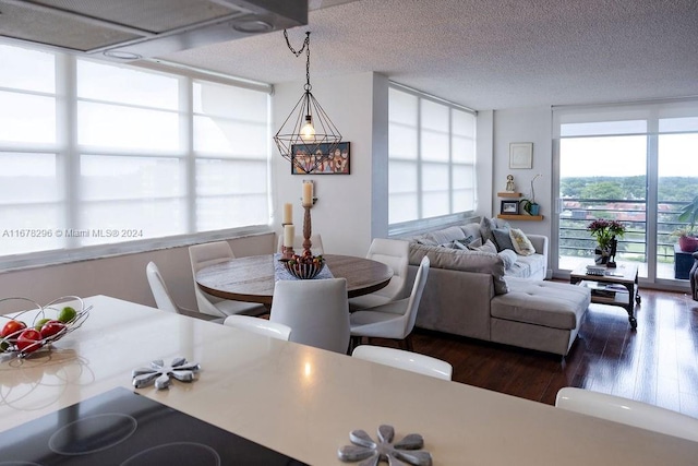 dining area featuring dark wood-type flooring and a textured ceiling