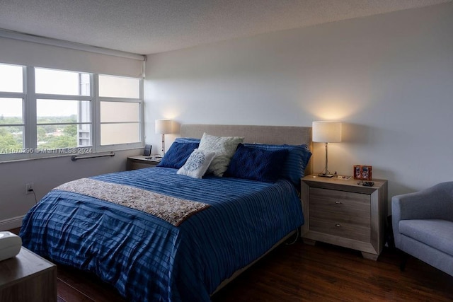 bedroom featuring dark hardwood / wood-style flooring and a textured ceiling